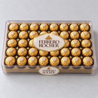 Ferrero Rocher chocolates in gold foil lined up in a clear plastic gift box, top view on white